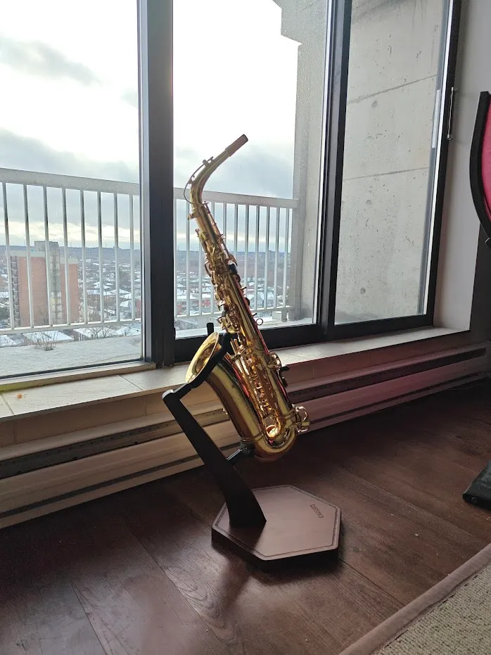 Alto saxophone propped up on a wooden stand